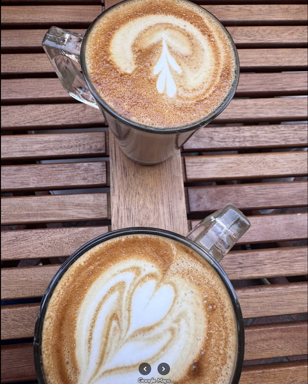 Two latte art coffees on wooden table